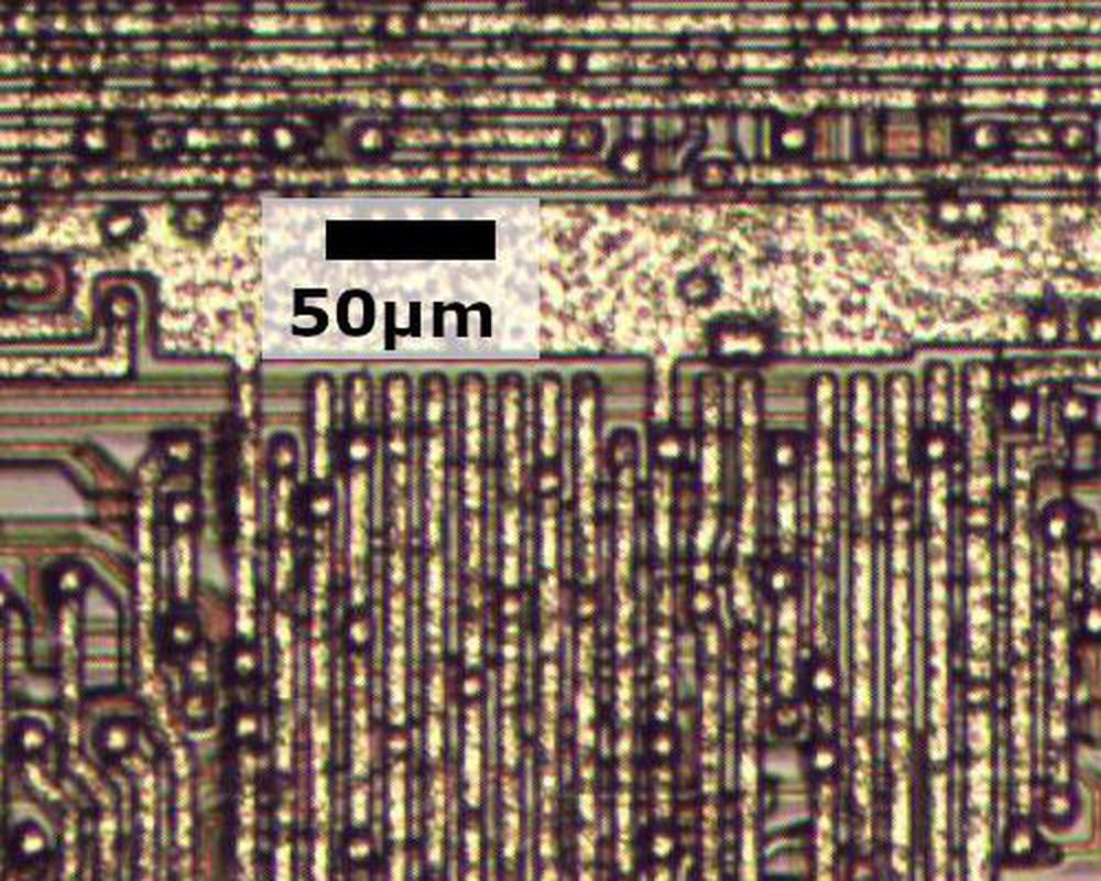 The metal layer of the older 8086 chip. Reddish polysilicon wiring is visible underneath the metal.