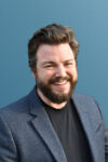 Kit Merker Headshot blazer gradient background sm