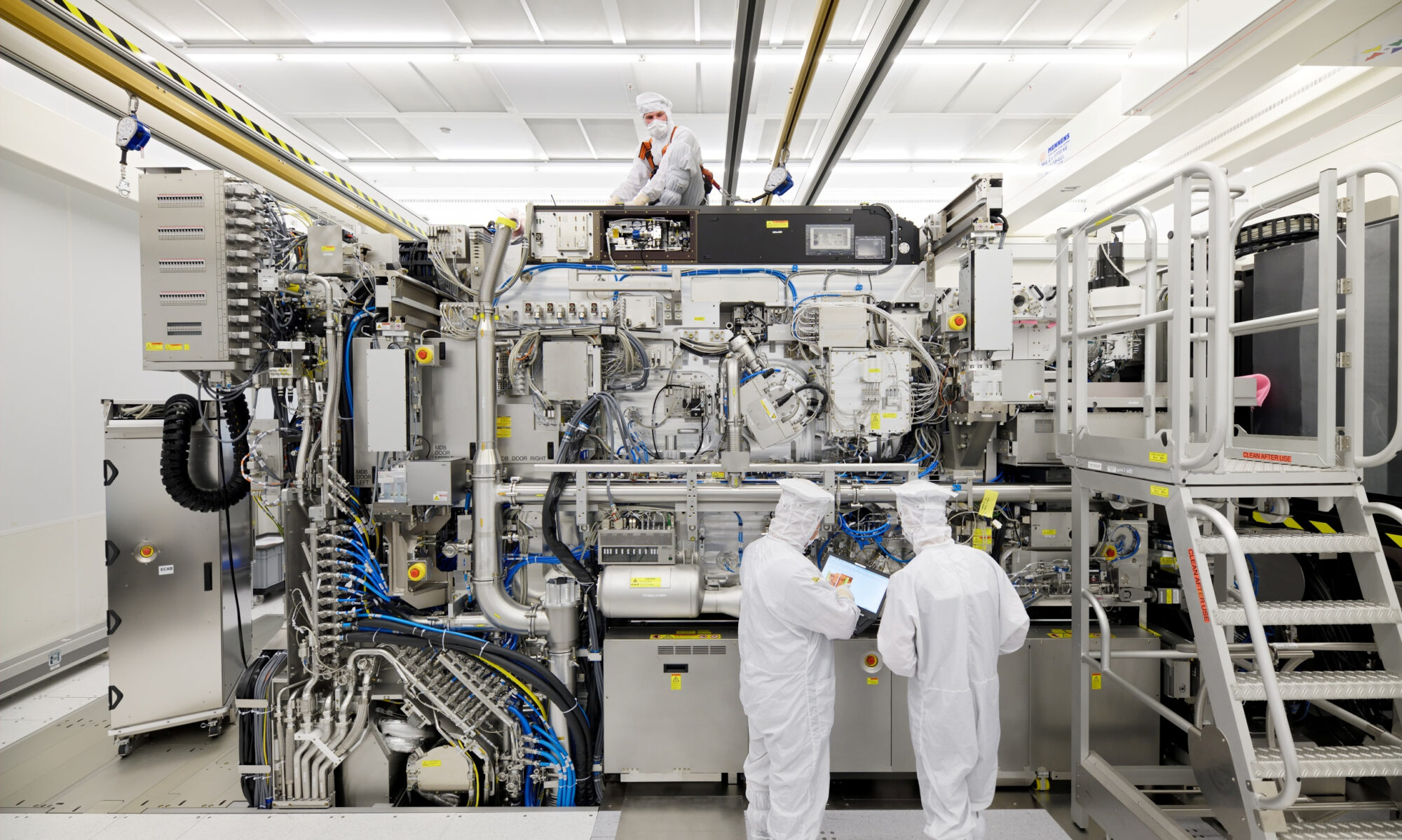 Employees are seen working on the final assembly of ASML's TWINSCAN NXE:3400B semiconductor lithography tool with its panels removed, in Veldhoven